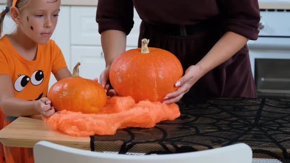 Girl with Mom Putting Pumpkins on Halloween Table