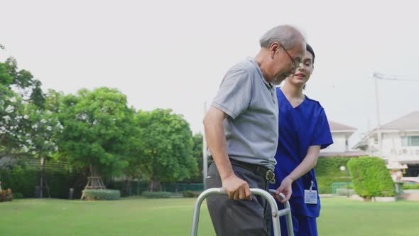 Asian young woman nurse at nursing home take care and physical disabled senior elderly man.