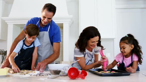 Happy family preparing cookies in kitchen