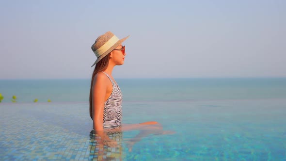 Young asian woman enjoy around outdoor swimming pool for leisure