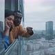 Multi ethnic couple enjoy view of city skyline and pointing fingures - VideoHive Item for Sale