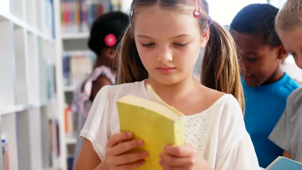 Girl looking at book in library