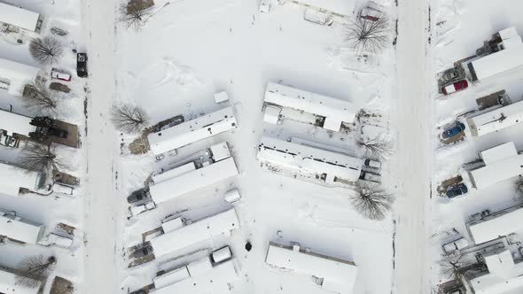 Aerial view over mobile home park in winter. Snow covered road through the rural trailer park.