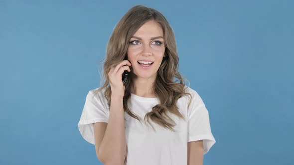 Young Girl Talking on Smartphone Isolated on Blue Background