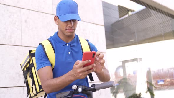 African Delivery Man Using Gps Smartphone Map App for Food Order Riding Electric Scooter