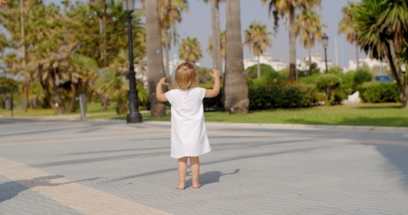 Small Girl Chasing Air Bubbles