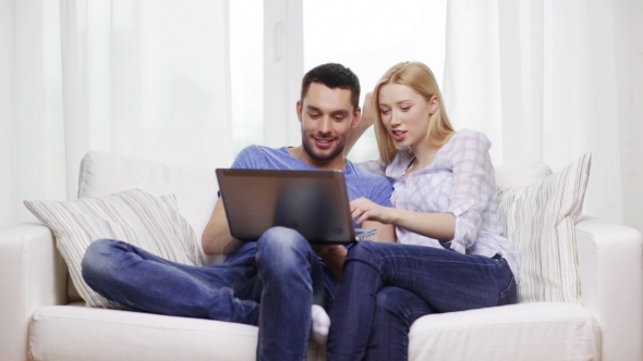 Happy Couple With Laptop Computer At Home