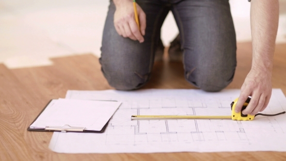 Male Hands With Measuring Tape And Blueprint