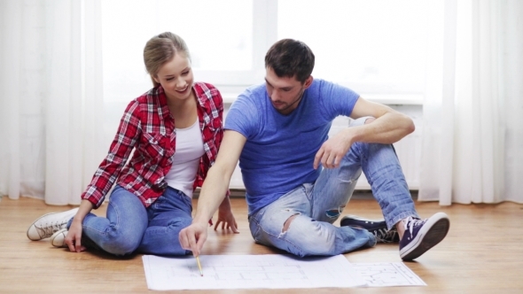 Happy Couple Discussing Blueprint At Home