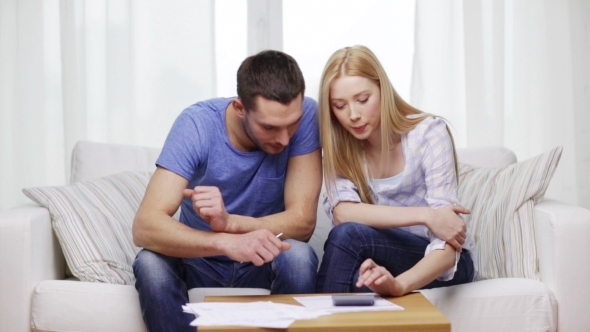 Busy Couple With Papers And Calculator At Home