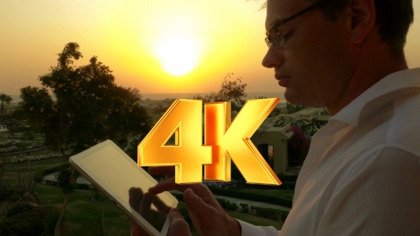 Businessman On Vacation Using Touch Pad At Sunset alt