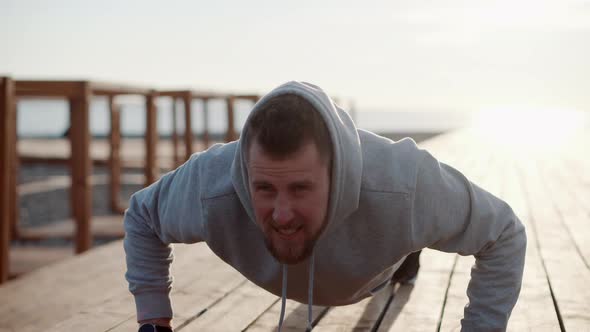 Strong Man Is Making Pushups Outdoors in Sunny Morning