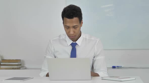 Angry AfroAmerican Businessman in Anger and Frustration Working on Laptop