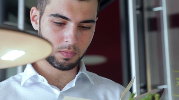 Young Man In Cafe Reading a Book alt