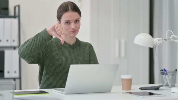 Thumbs Down By Young Woman with Laptop 