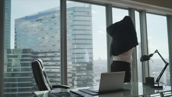 Successful Businessman in White Shirt and Black Pants Standing and Holding Netbook While Throwing