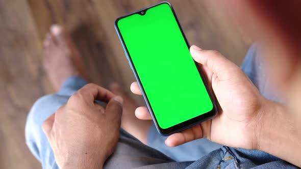 Rear View of Young Man Using Smart Phone Indoor