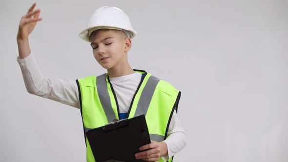 Confident Little Construction Foreman in Hard Hat Gesturing Yelling Talking Standing with Plan at