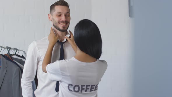 Woman Tying Necktie for Husband in Morning