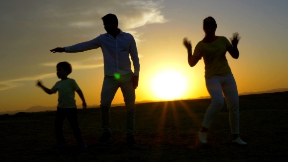 Happy Family Dancing On The Beach