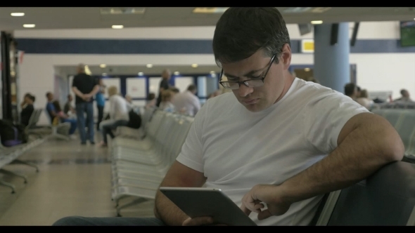 Man Passing Time Before Departure With Tablet 