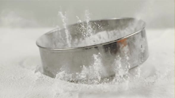 Super Slow Motion Sieve with Flour Falls on the Table