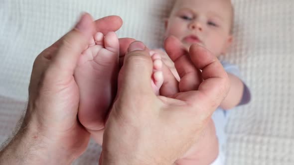 Father Holding Baby Feet in Hands