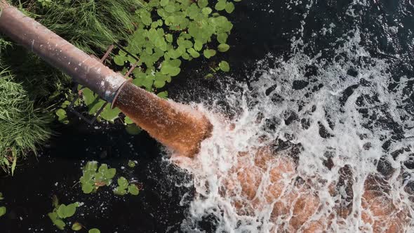 Dirty sewage is pouring from the pipe, industrial waste, man-made pollution of the environment.