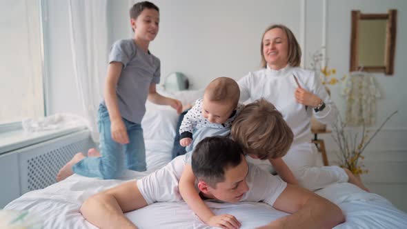 Family with Three Kids Having Fun in Bed