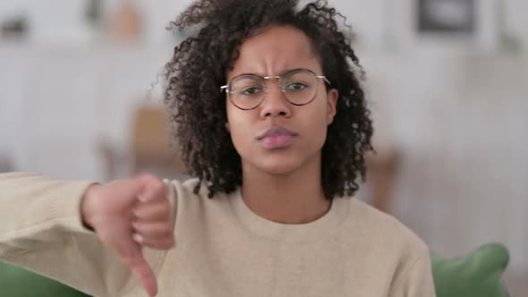 Portrait of African Woman with Thumbs Down at Home