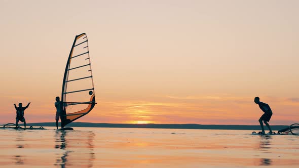 Men Are Jumping Off of Their Sailboards in the Sea