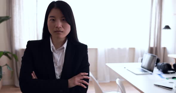 Asian young woman looking on camera inside modern office