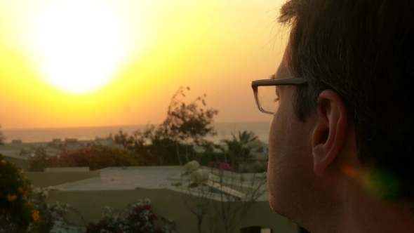 Man Putting On Glasses And Enjoying Nature Scene alt