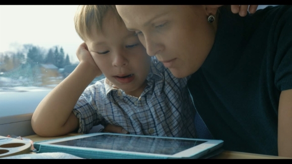 Boy And His Mother Watching Cartooins In Tablet