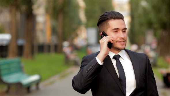 Young Businessman Talking On Mobile Phone alt