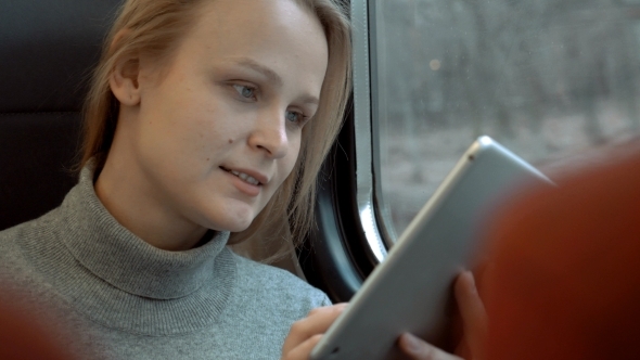 Smiling Woman With Tablet In Train alt