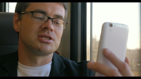 Man Having a Video Chat On Mobile During Train alt