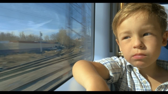 Little Boy Looking Out Train Window On Sunny Day
