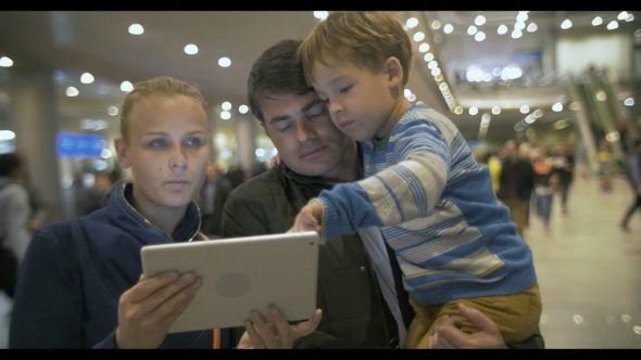 Parents And Child With Pad At The Crowded Airport alt