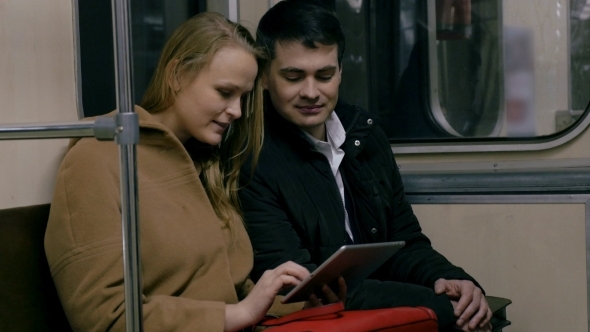 Couple With Tablet PC In Public Transport alt