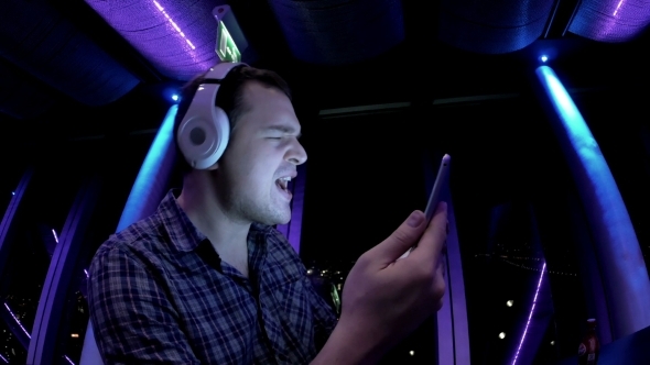 Young Man Enjoying The Music In Tablet alt