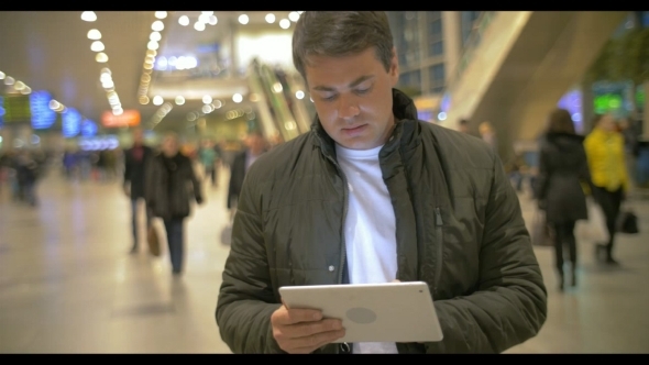 Man Using Digital Tablet In Airport Hall alt