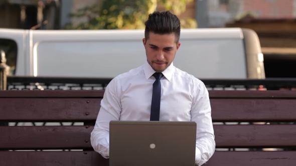 Young Man Working With a Laptop In Park alt