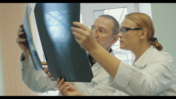 Doctors Analyzing The Results Of X-ray Examination alt