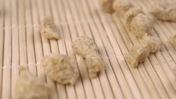 Dried soybeans close-up on bamboo mat surface. Falling in slow motion