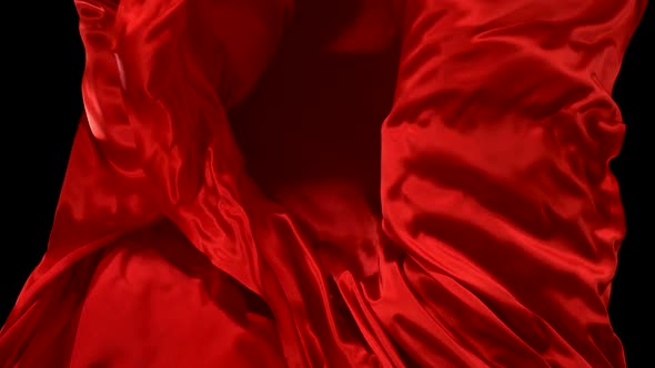 Clear glass ball falling onto red cloth, Slow Motion