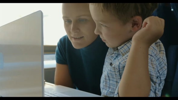 Mother And Son In Front Of Laptop In Train alt