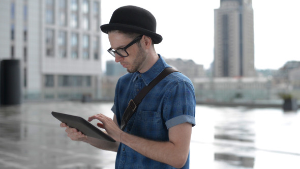 Young Man Typing on Tablet