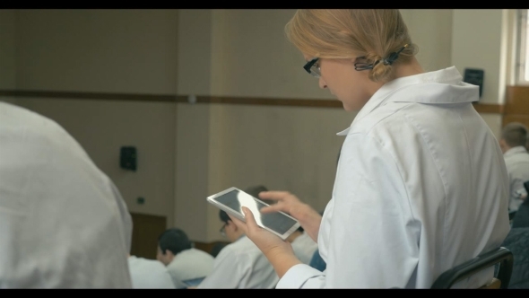 Medical Student Taking Notes On Pad During Lecture alt