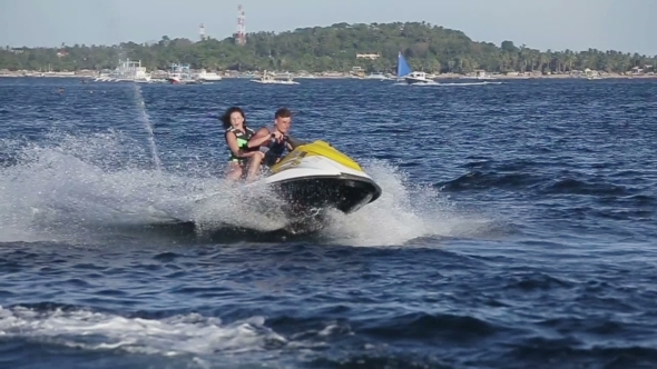 Happy Couple Riding Jet Ski